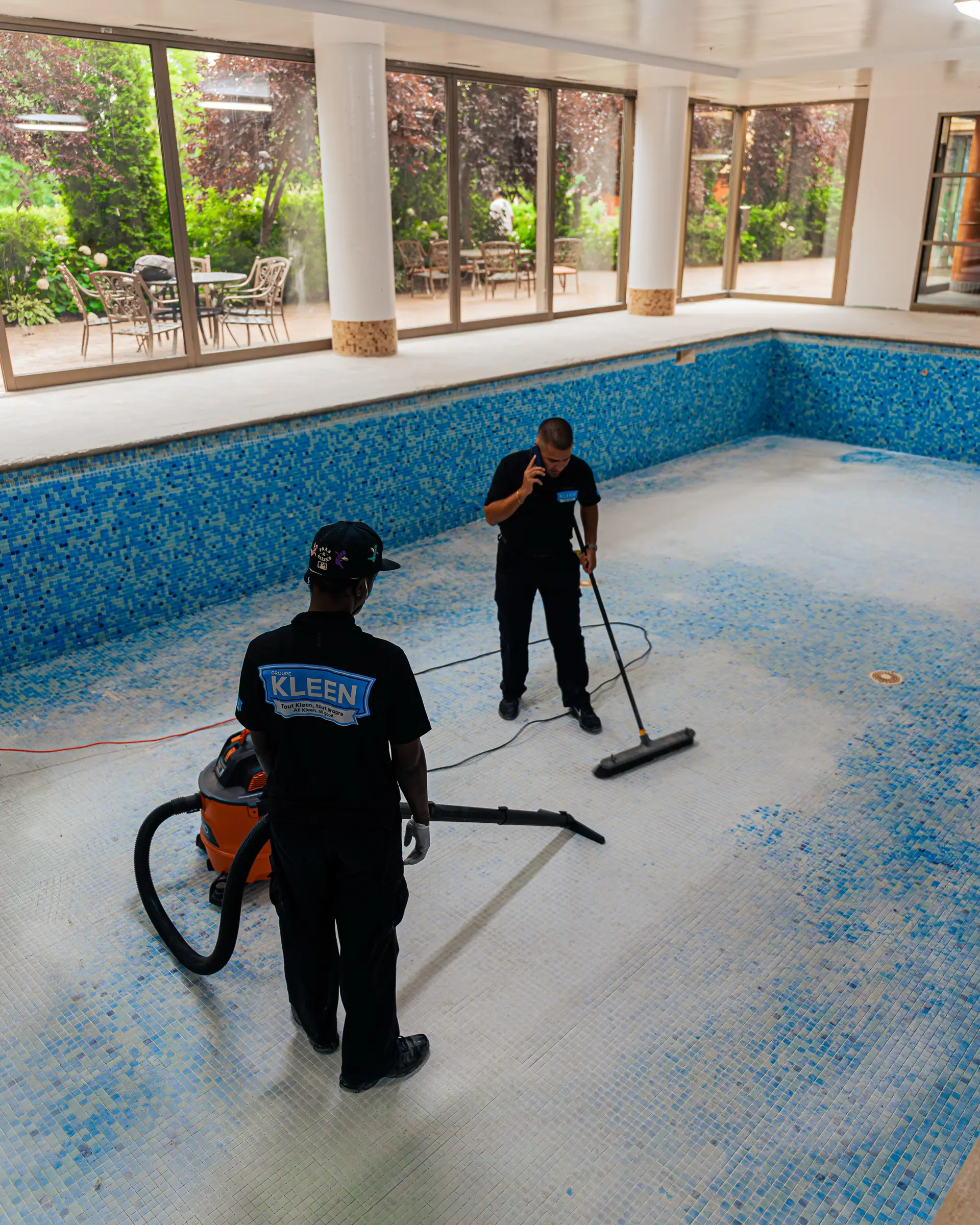 Deux membres de l’équipe KLEEN nettoient une piscine intérieure