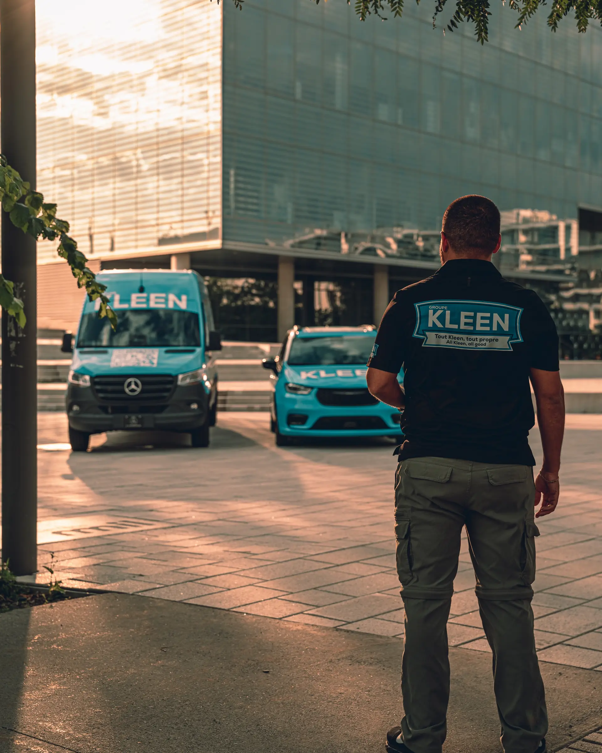 Membre de l’équipe Groupe KLEEN devant les véhicules de service