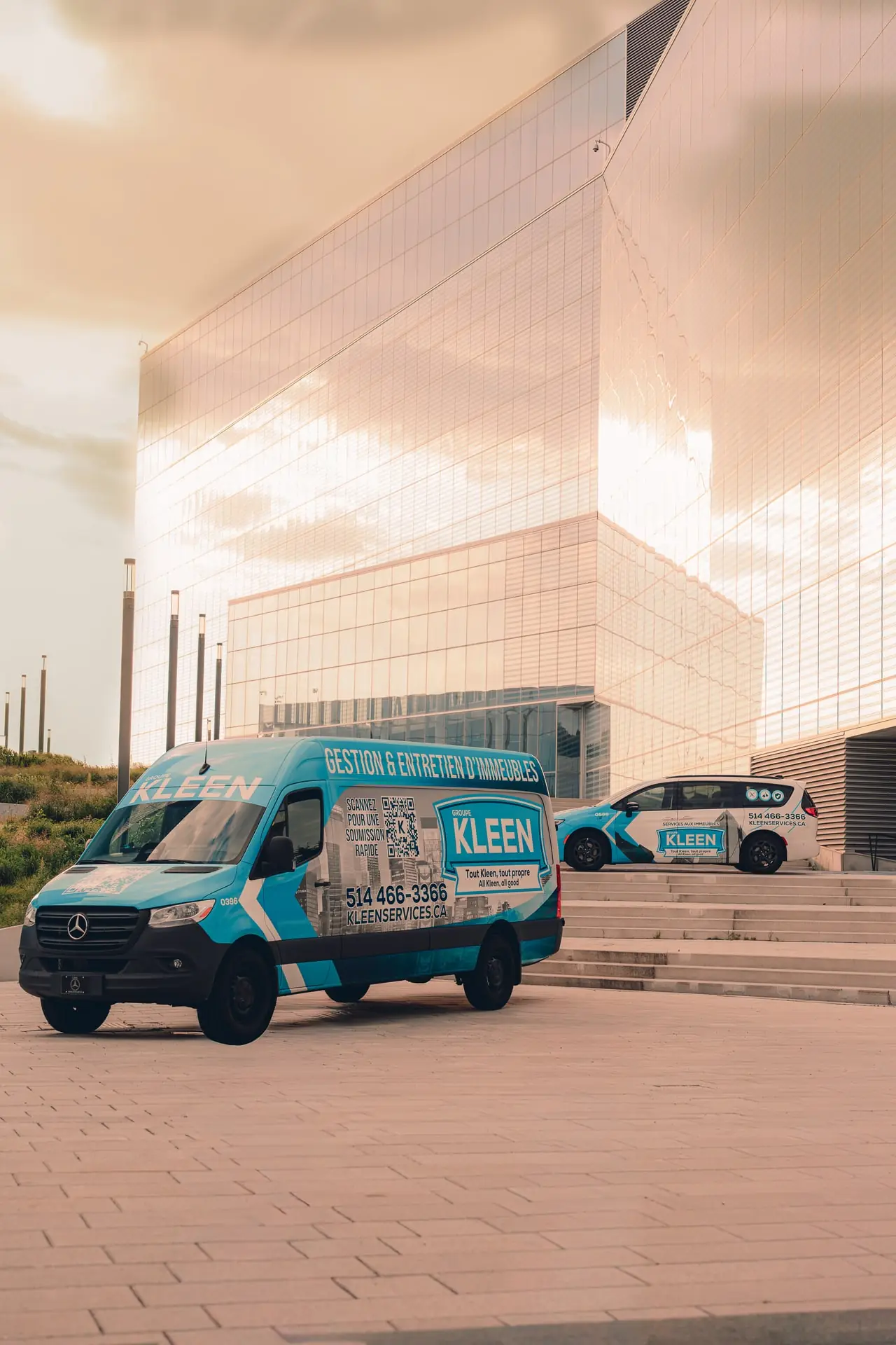 Three-quarter view of a KLEEN van on a plaza in evening light