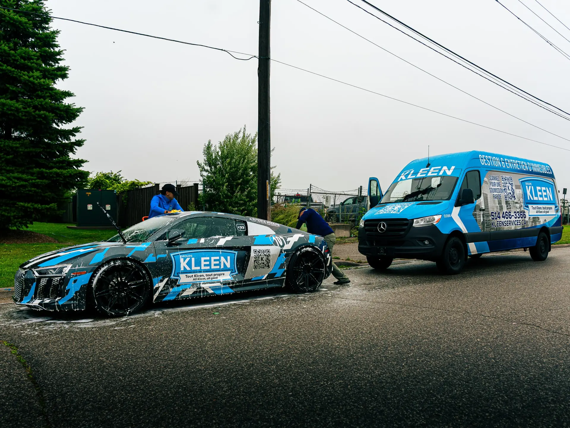 Team members washing a KLEEN car beside the van