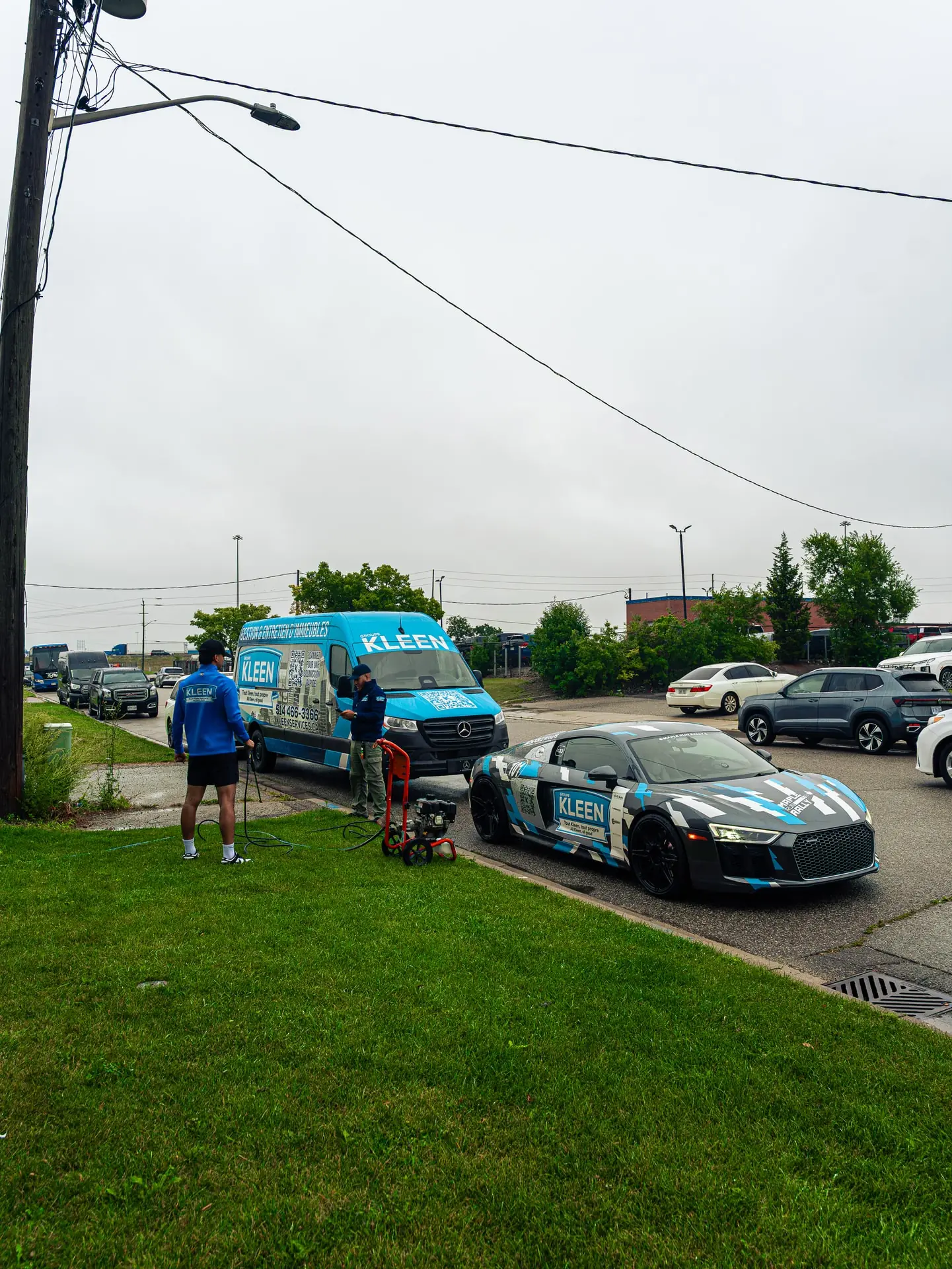 Team with washing equipment beside a KLEEN car and van