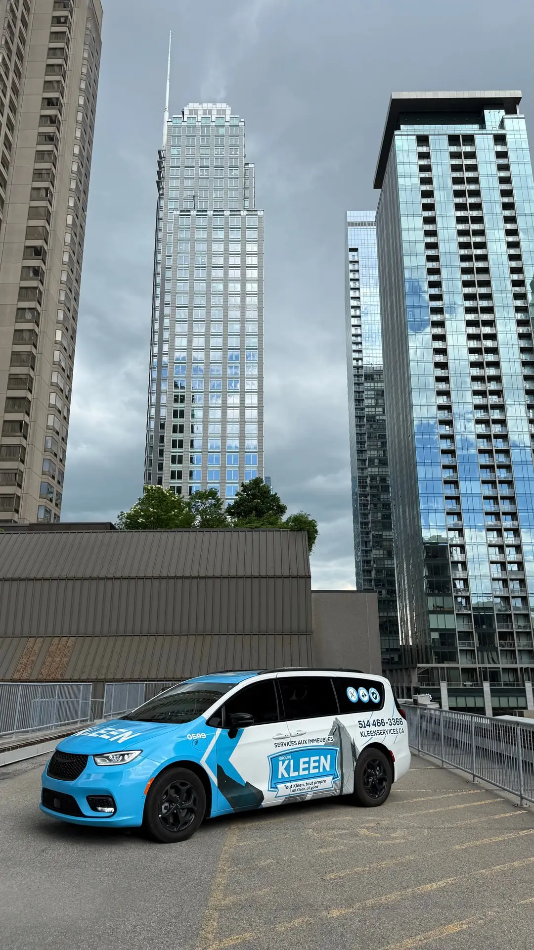Three-quarter view of a KLEEN minivan near residences
