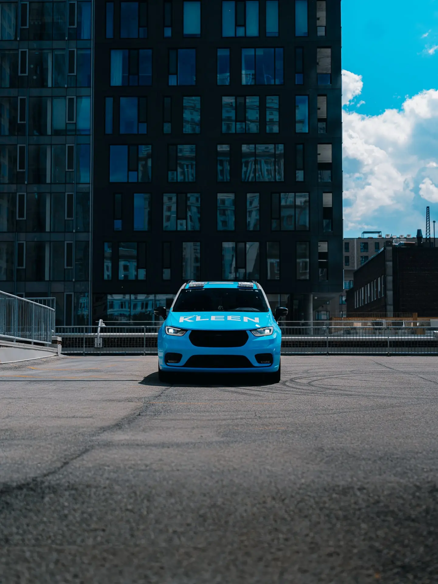 Front view of a KLEEN vehicle between tall city buildings