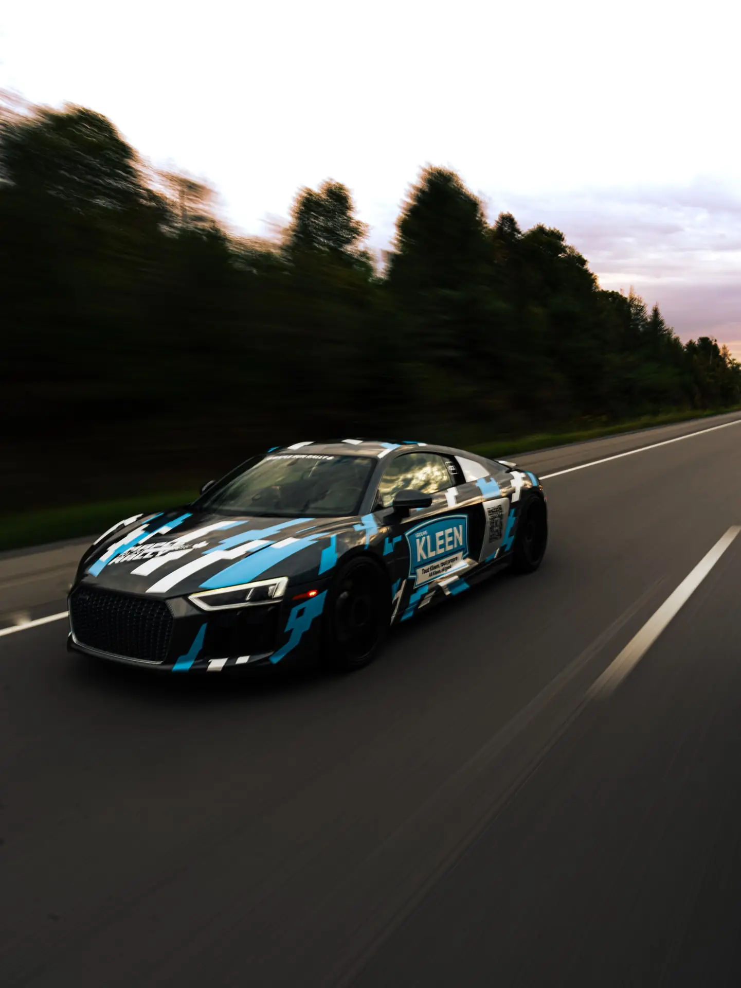 KLEEN-branded car photographed in motion on the road