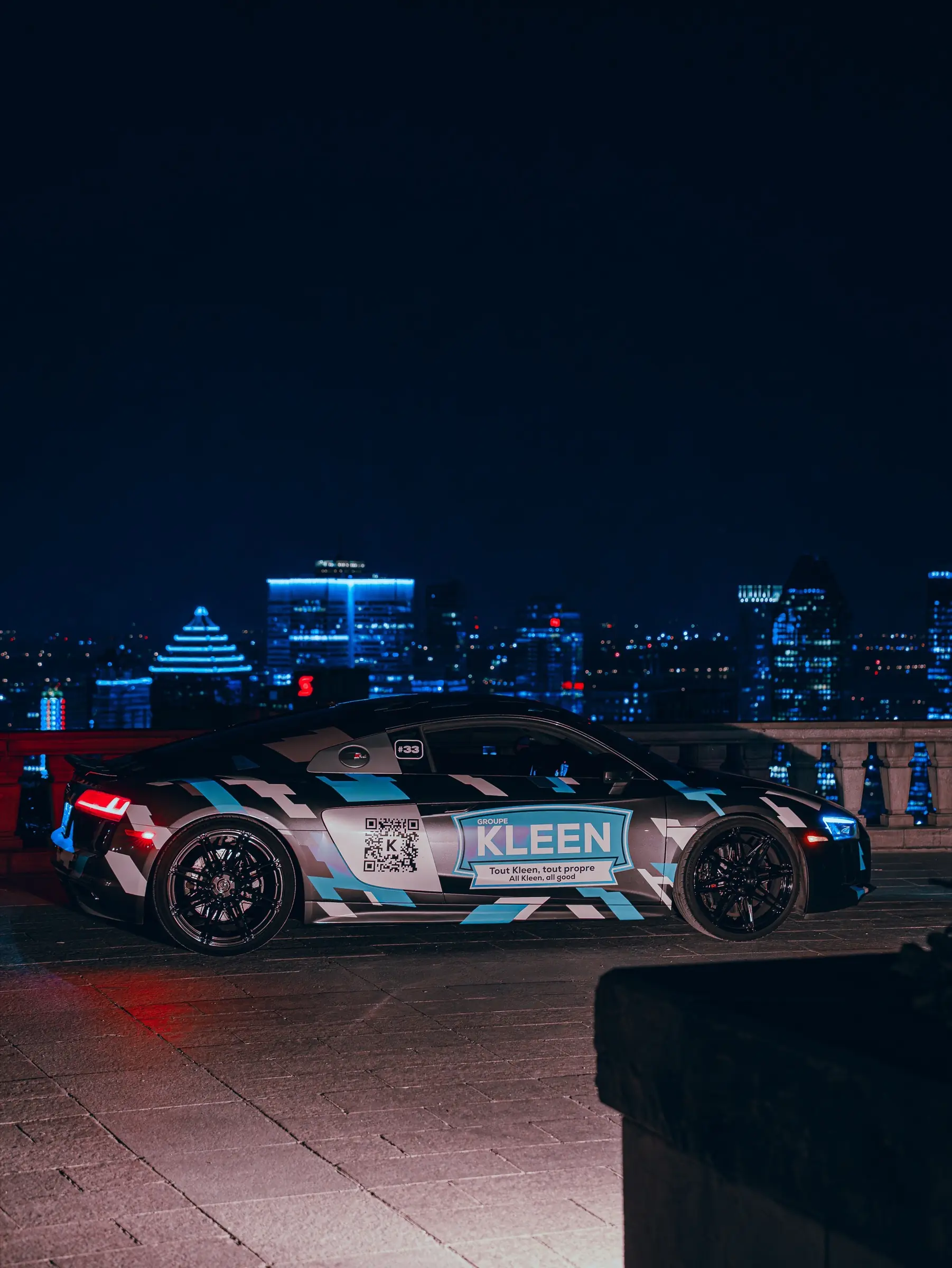 Audi R8 aux couleurs de Groupe KLEEN devant Montréal illuminée, de nuit